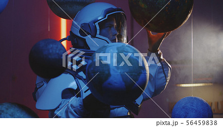Student in space suit revolving planet model 56459838