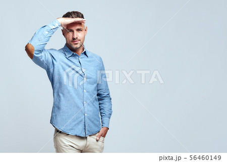 I'm watching you. Young bearded and handsome man in casual clothes is looking far away, searching 56460149