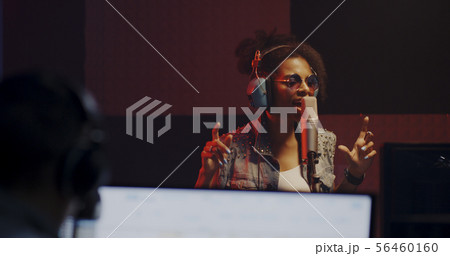 Woman singing in recording booth 56460160