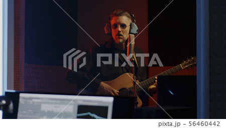 Guitarist and sound engineer working in studio 56460442