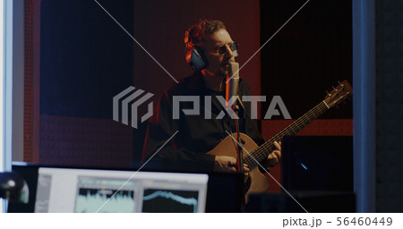 Guitarist and sound engineer working in studio 56460449
