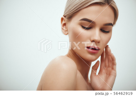 I love my skin. Attractive young blonde woman keeping eyes closed and touching her face while I love my skin. Attractive young blonde woman keeping eyes closed and touching her face while 56462919