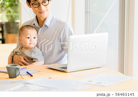 子供を抱きながら仕事をする男性 56463145