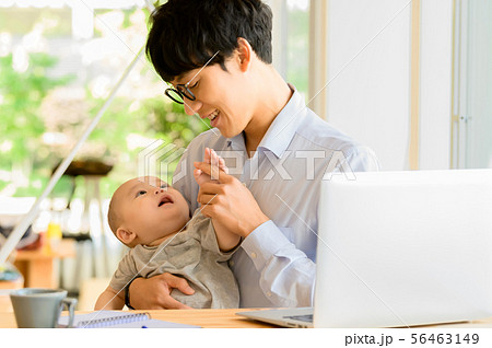 子供を抱きながら仕事をする男性 子供を抱きながら仕事をする男性 56463149