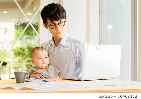子供を抱きながら仕事をする男性 子供を抱きながら仕事をする男性 56463152