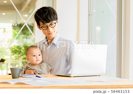 子供を抱きながら仕事をする男性 子供を抱きながら仕事をする男性 56463153