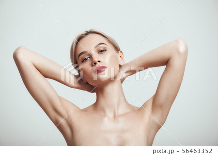 Freshness. Young healthy woman holding her arms up and showing clean underarms while standing Freshness. Young healthy woman holding her arms up and showing clean underarms while standing 56463352