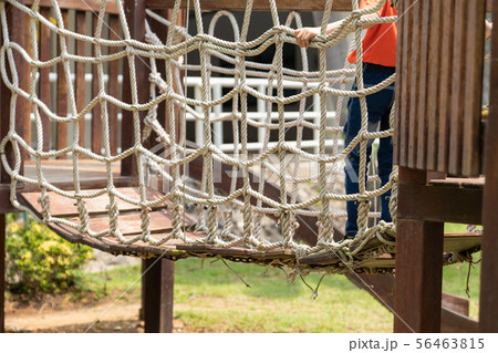 A boy walking on net playground. 56463815