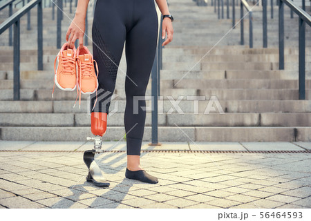 Keeping my body healthy. Cropped photo of woman with leg prosthesis in sports clothing carrying her Keeping my body healthy. Cropped photo of woman with leg prosthesis in sports clothing carrying her 56464593