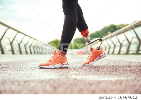 Cropped view of disabled woman with leg prosthesis standing on the bridge in the morning 56464612