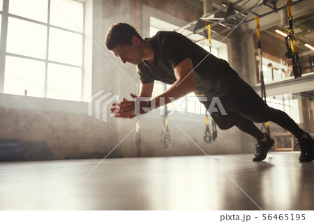 Strength and motivation. Full length of young athletic man in sportswear doing push-up exercises at Strength and motivation. Full length of young athletic man in sportswear doing push-up exercises at 56465195