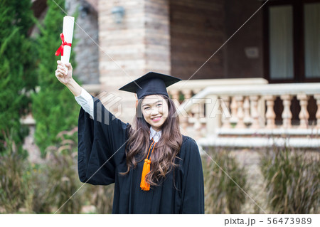 Graduate celebrating with certificate in her hand Graduate celebrating with certificate in her hand 56473989