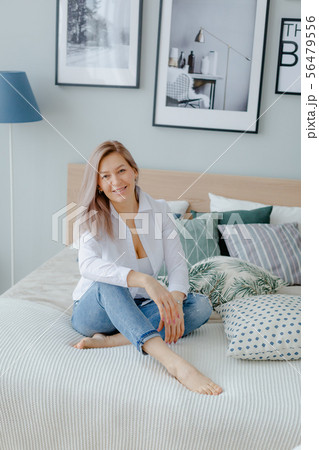 A blonde woman on the bed in the morning A blonde woman on the bed in the morning 56479556
