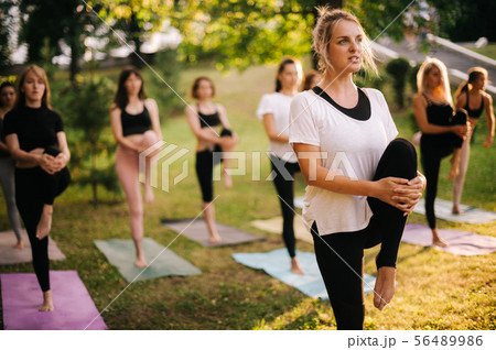 Group of young women are balancing on one leg and pulling up one leg 56489986