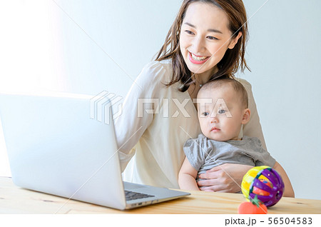 子供を抱きながらパソコンを操作する女性 56504583