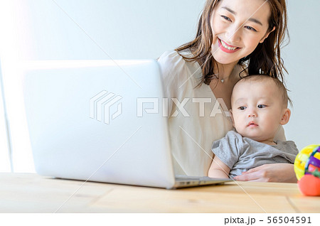 子供を抱きながらパソコンを操作する女性 56504591