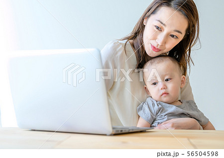 子供を抱きながらパソコンを操作する女性 56504598