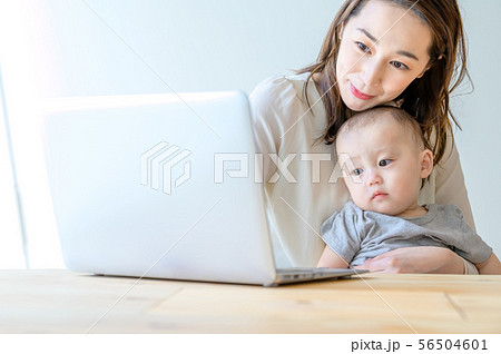 子供を抱きながらパソコンを操作する女性 56504601
