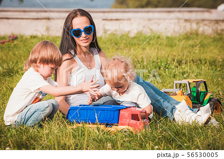 happy family young mother and sons spending time outdoor on a summer day happy family young mother and sons spending time outdoor on a summer day 56530005