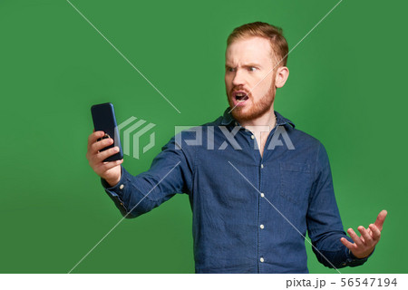 Indignant man reading text message Indignant man reading text message 56547194