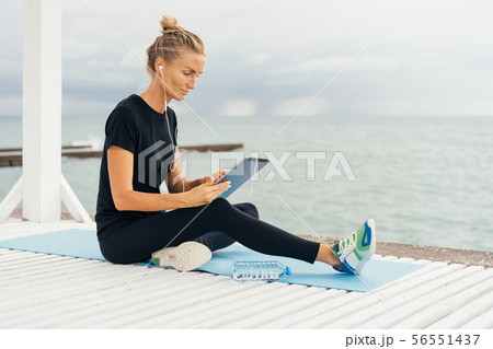 girl in sportswear surfing in tablet 56551437