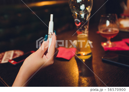 heat-not-burn tobacco product technology. Man holding e-cigarette in his hand before smoking. heat-not-burn tobacco product technology. Man holding e-cigarette in his hand before smoking. 56570900