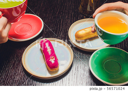 Glazed Cherry eclair on white dish topped with chocolate scribble candy served with a side of 56571024