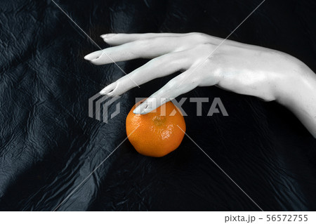 white hand of mannequin with orange fruit white hand of mannequin with orange fruit 56572755