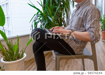 膝の上でノートパソコンを操作する男性 56574244