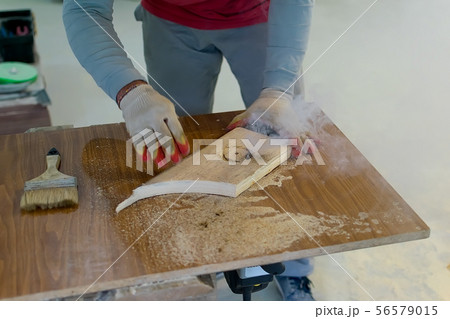 Hands of the master in gloves hold a wooden billet Hands of the master in gloves hold a wooden billet 56579015