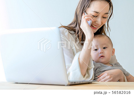 子供を抱きながら電話をする女性 56582016