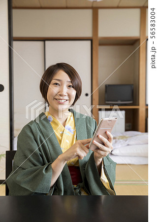 温泉旅館の客室でスマホを操作する女性　女子旅 56583004