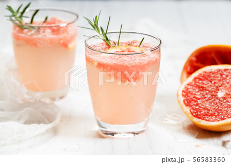 Glass of grapefruit drink with ice and rosemary Glass of grapefruit drink with ice and rosemary 56583360