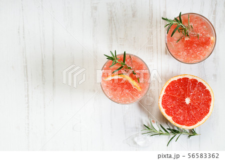 Glass of grapefruit drink with ice and rosemary Glass of grapefruit drink with ice and rosemary 56583362