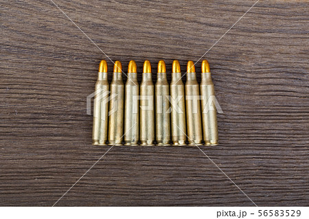 Rifle bullets on wood table close up. Rifle bullets on wood table close up. 56583529