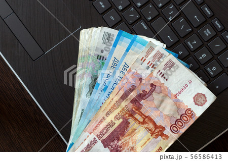 A stack of Russian rubles of different denominations lies on the laptop keyboard. A stack of Russian rubles of different denominations lies on the laptop keyboard. 56586413
