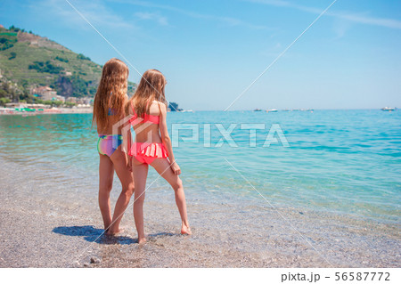 Two little happy girls have a lot of fun at tropical beach playing together 56587772