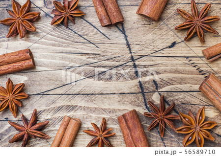 Cinnamon sticks and anise stars on wooden backgrou 56589710