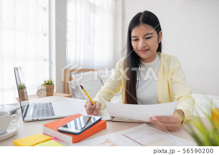 Asian female freelancer reading report on laptop Asian female freelancer reading report on laptop 56590200