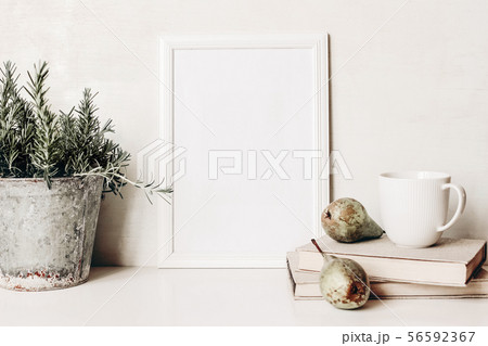 White vertical blank wooden frame mockup. Composition of rosemary herb in old metal flower pot White vertical blank wooden frame mockup. Composition of rosemary herb in old metal flower pot 56592367