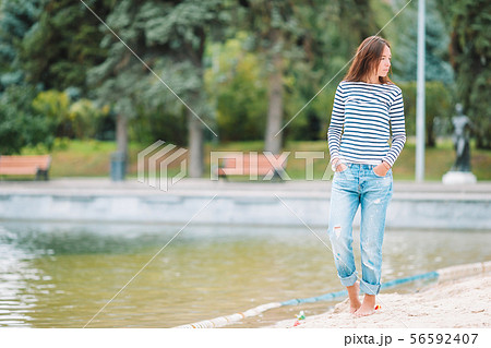 Young happy woman walking near the lake at warm autumn day 56592407