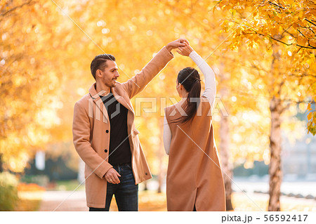 Happy family walking in autumn park on sunny fall day Happy family walking in autumn park on sunny fall day 56592417