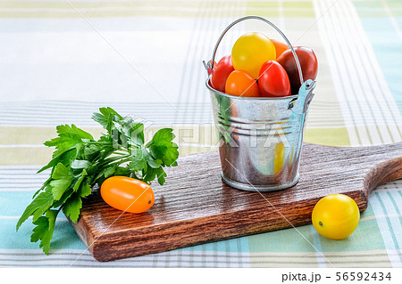 Ripe multicolored mini tomatoes in a small bucket Ripe multicolored mini tomatoes in a small bucket 56592434