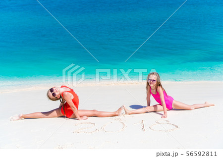 Little girls having fun at tropical beach playing together at shallow water 56592811