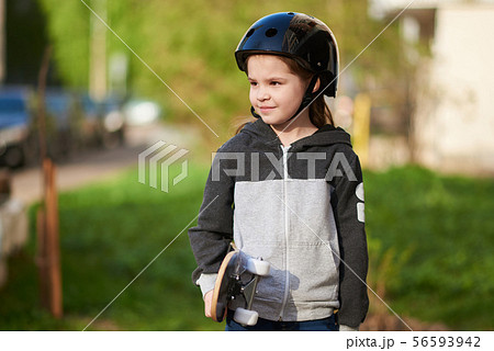 Little girl with a skate and in a helmet. Little girl with a skate and in a helmet. 56593942