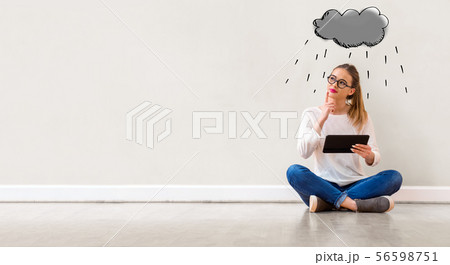 Rain cloud with woman using a tablet 56598751