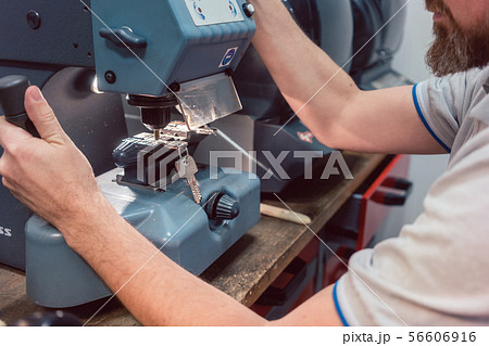 Locksmith cutting key with his machine Locksmith cutting key with his machine 56606916