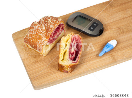 Cherry strudel and glucometer on a cutting board 56608348