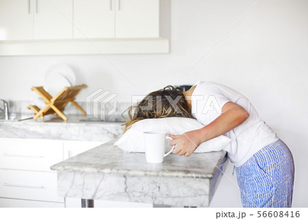 Sleppy woman with cup of coffee and pillow on the Sleppy woman with cup of coffee and pillow on the 56608416