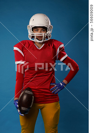 Photo of young american woman football player in white helmet, sportswear with ball in her hand Photo of young american woman football player in white helmet, sportswear with ball in her hand 56609009